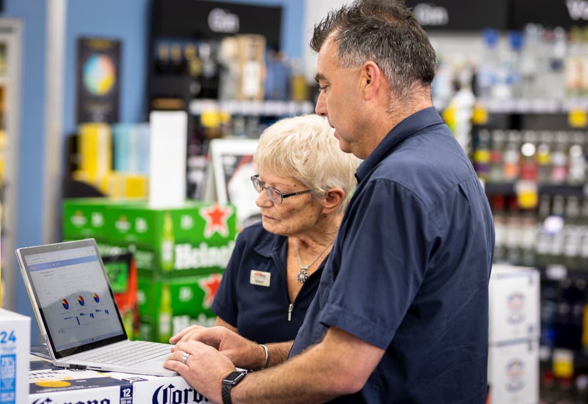 Super Liquor franchise manager Paul Webster discussing sales data with store manager Robyn Neame